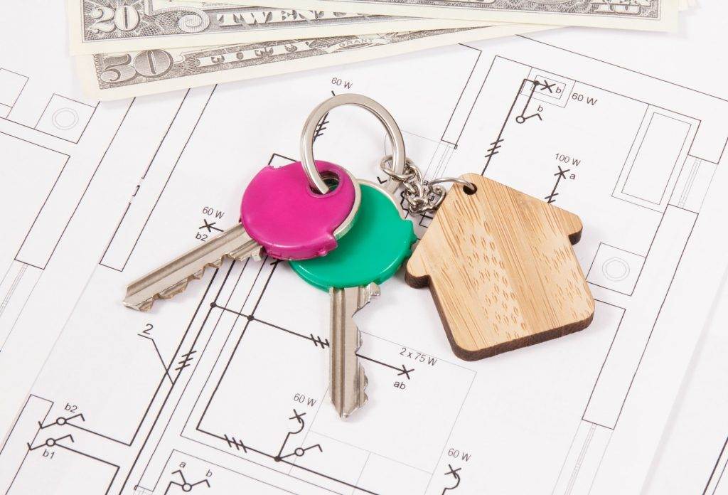 Keys with home shape and dollar on diagrams of house. Building or buying home